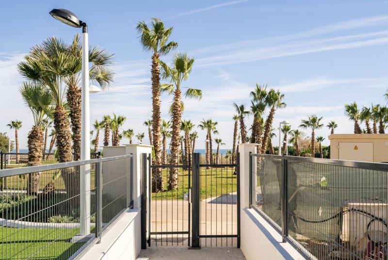 Puerta del residencial que sale al paseo de la playa